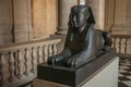 Ancient sculpture of Egyptian sphinx sitting at the Louvre Museum in Paris.